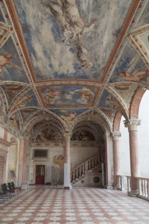 ceiling in Trento castle -- top is all painting with a lot of blue and then two arches and a tiled floor